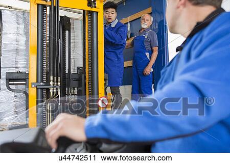 Stock Image - Factory worker operating forklift. Fotosearch