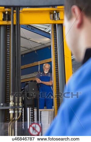 Stock Photo - Factory worker operating forklift. Fotosearch