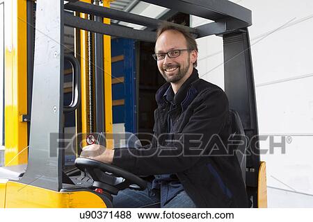 Stock Photo - Factory worker operating forklift. Fotosearch
