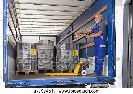 Factory worker operating pallet jack View Large Photo Image Stock Image - Factory worker operating pallet jack. Fotosearch