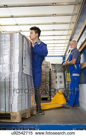 Factory worker operating pallet jack View Large Photo Image Stock Photography - Factory worker operating pallet jack. Fotosearch