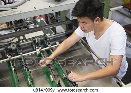 Stock Photo - Factory worker working machinery. Fotosearch