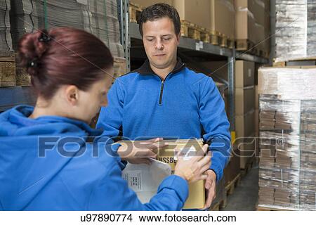 Picture - Factory workers labelling parcel. Fotosearch