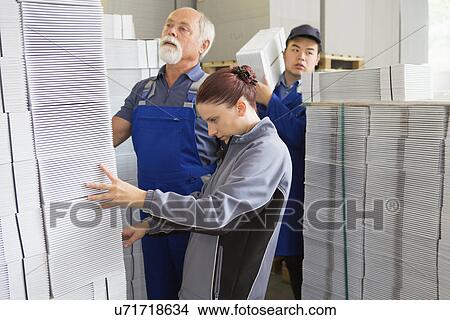 Factory workers moving and stacking cardboard View Large Photo Image Picture - Factory workers moving and stacking cardboard. Fotosearch