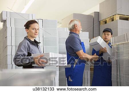 Factory workers moving and stacking cardboard View Large Photo Image Stock Image - Factory workers moving and stacking cardboard. Fotosearch