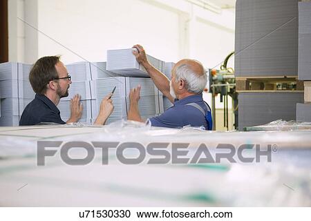 Factory workers moving and stacking cardboard View Large Photo Image Stock Image - Factory workers moving and stacking cardboard. Fotosearch