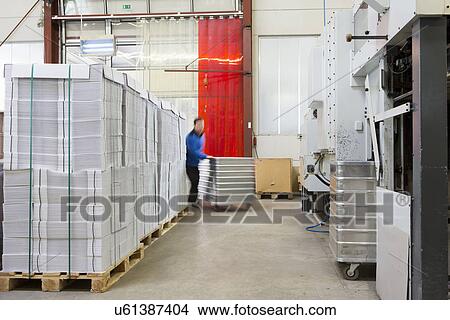 Factory workers moving containers of cardboard View Large Photo Image Picture - Factory workers moving containers of cardboard. Fotosearch