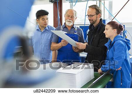 Stock Photo - Factory workers with supervisor. Fotosearch