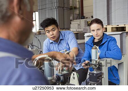 Stock Image - Factory workers working machinery. Fotosearch