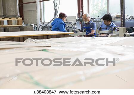 Factory workers working machinery View Large Photo Image Stock Photo - Factory workers working machinery. Fotosearch