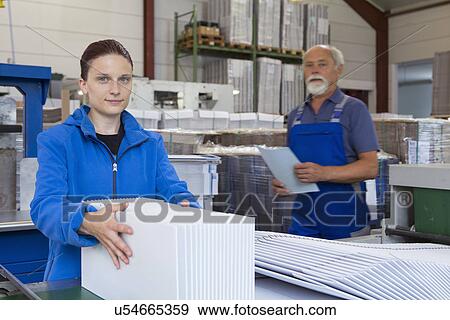 Stock Photo - Factory workers working with cardboard. Fotosearch