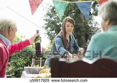 Stock Photo - Family having lunch outdoors. Fotosearch