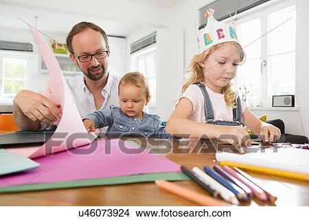 Family making paper crowns View Large Photo Image Picture - Family making paper crowns. Fotosearch