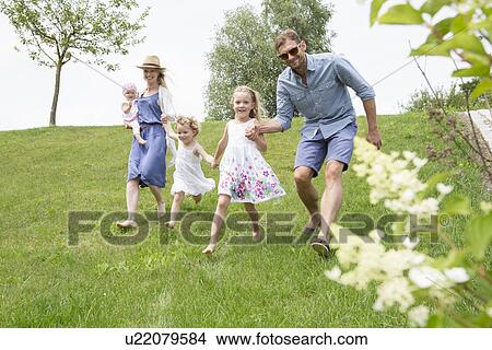 Family running through field View Large Photo Image Picture - Family running through field. Fotosearch