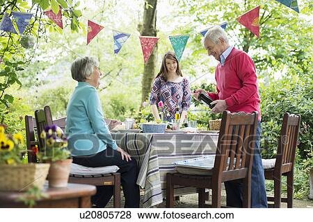 Family sitting down for an outdoor meal View Large Photo Image Stock Photo - Family sitting down for an outdoor meal. Fotosearch