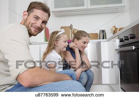 Stock Photo - Family watching oven. Fotosearch