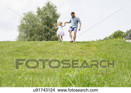 Father and daughter running downhill View Large Photo Image Picture - Father and daughter running downhill. Fotosearch