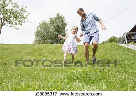 Father and daughter running downhill View Large Photo Image Stock Photo - Father and daughter running downhill. Fotosearch