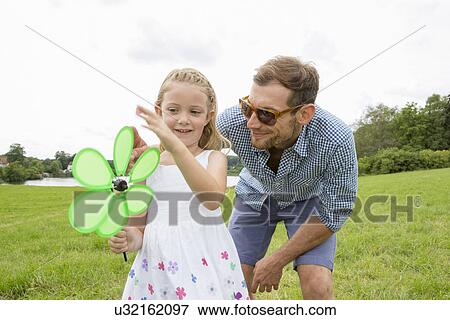 Stock Photo - Father and daughter with flower shaped pinwheel. Fotosearch