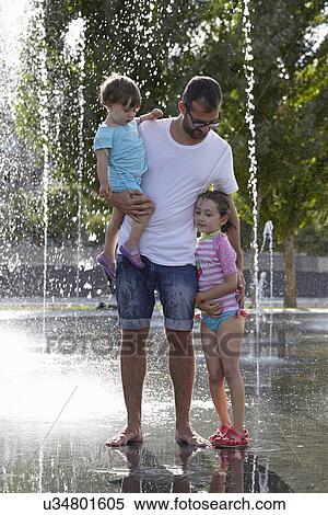 Father and two daughters playing in water fountains, Madrid, Spain View Large Photo Image Stock Photography - Father and two daughters playing in water fountains, Madrid, Spain. Fotosearch