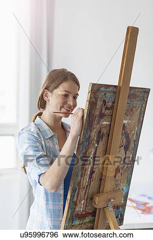 Female artist painting at easel View Large Photo Image Stock Photograph - Female artist painting at easel. Fotosearch