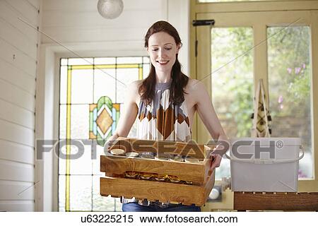 Female beekeeper in kitchen carrying a crate of honey jars from beehive View Large Photo Image Stock Photography - Female beekeeper in kitchen carrying a crate of honey jars from beehive. Fotosearch