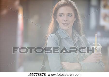 Stock Photo - Female shopper with drink in plastic cup. Fotosearch