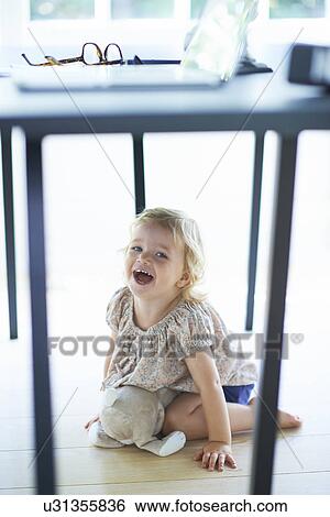 Female toddler hiding and laughing under dining room table View Large Photo Image Stock Photograph - Female toddler hiding and laughing under dining room table. Fotosearch
