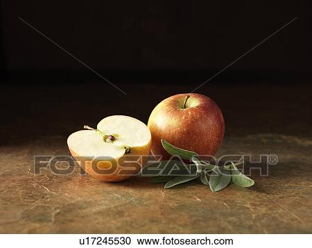 Stock Image - Festive Christmas ingredients of apples and sage for stuffing pork and onion balls with apple sauce centres. Fotosearch