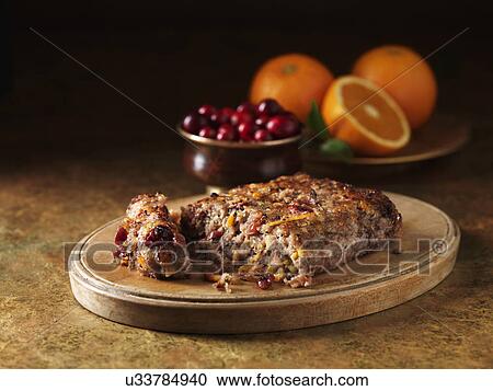 Stock Image - Festive Christmas ingredients of pork, cranberry & orange stuffing on chopping board. Fotosearch