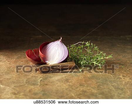 Stock Photograph - Festive Christmas ingredients of red onion, thyme and cinnamon for spiced bacon & venison cocktail sausage rolls. Fotosearch