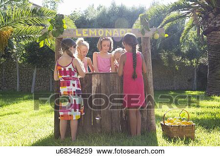 Stock Photo - Five girls buying and selling fresh lemonade at lemonade stand in park. Fotosearch