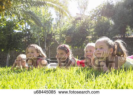 Five girls lying in a row in garden with chins on hands View Large Photo Image Stock Photography - Five girls lying in a row in garden with chins on hands. Fotosearch