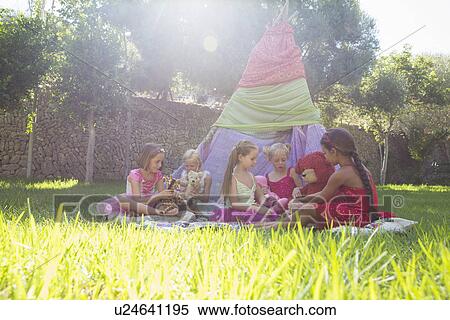 Stock Photography - Five girls playing with teddy bears in front of teepee. Fotosearch