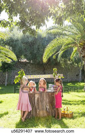 Stock Photo - Four girls chatting at lemonade stand in park. Fotosearch
