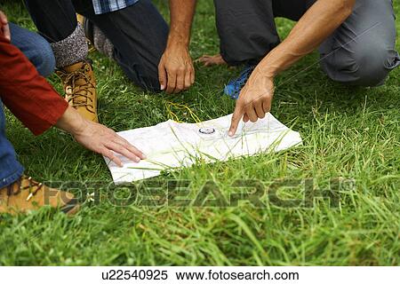 Friends reading map on grass View Large Photo Image Stock Photography - Friends reading map on grass. Fotosearch