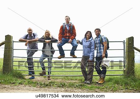 Friends standing at gate in fields View Large Photo Image Picture - Friends standing at gate in fields. Fotosearch