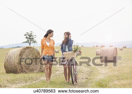 Friends with bicycle walking on field, Roznov, Czech Republic View Large Photo Image Stock Image - Friends with bicycle walking on field, Roznov, Czech Republic. Fotosearch