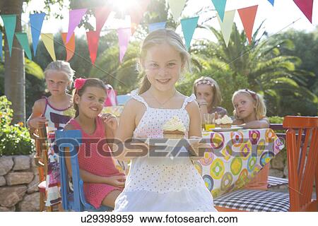 Girl at birthday party holding plate with cupcake View Large Photo Image Stock Photo - Girl at birthday party holding plate with cupcake. Fotosearch