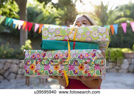 Girl carrying pile of birthday presents View Large Photo Image Stock Image - Girl carrying pile of birthday presents. Fotosearch