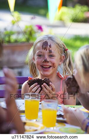 Girl eating chocolate cake, face covered in icing View Large Photo Image Picture - Girl eating chocolate cake, face covered in icing. Fotosearch