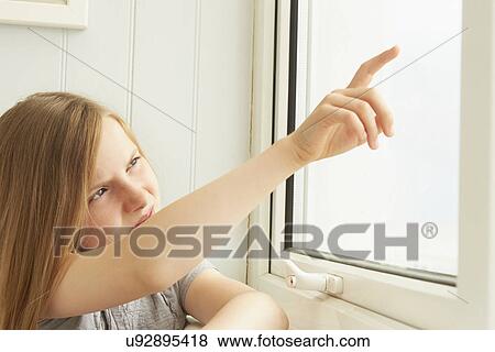 Girl pointing out of holiday apartment window View Large Photo Image Stock Photo - Girl pointing out of holiday apartment window. Fotosearch