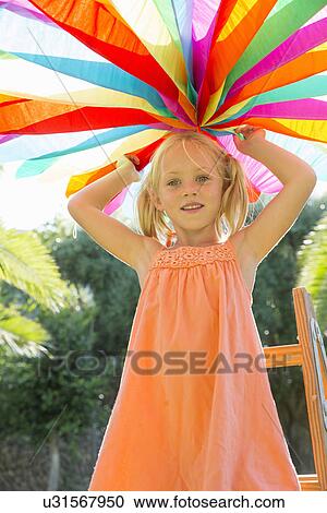Girl putting up decoration in garden View Large Photo Image Stock Image - Girl putting up decoration in garden. Fotosearch
