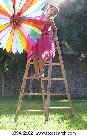 Girl putting up decoration in garden View Large Photo Image Stock Image - Girl putting up decoration in garden. Fotosearch