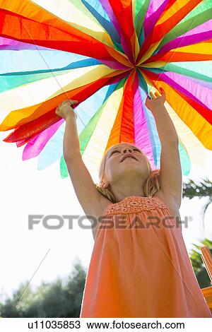 Stock Image - Girl putting up decoration. Fotosearch