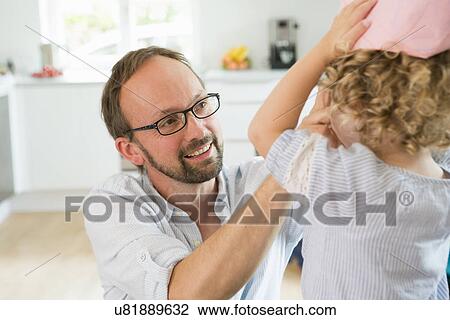 Stock Image - Girl trying on paper crown with father. Fotosearch