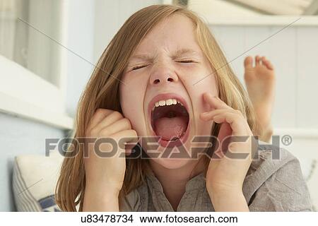 Picture - Girl with eyes closed screaming in holiday apartment. Fotosearch