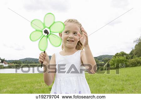 Girl with flower shaped pinwheel View Large Photo Image Picture - Girl with flower shaped pinwheel. Fotosearch