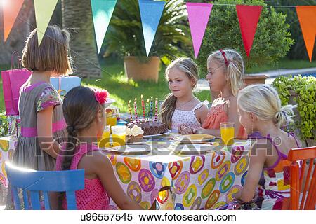 Girl with friends at table with birthday cake View Large Photo Image Stock Photography - Girl with friends at table with birthday cake. Fotosearch