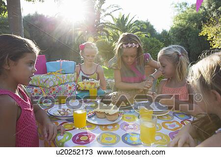 Girls cutting birthday cake with friends View Large Photo Image Stock Image - Girls cutting birthday cake with friends. Fotosearch